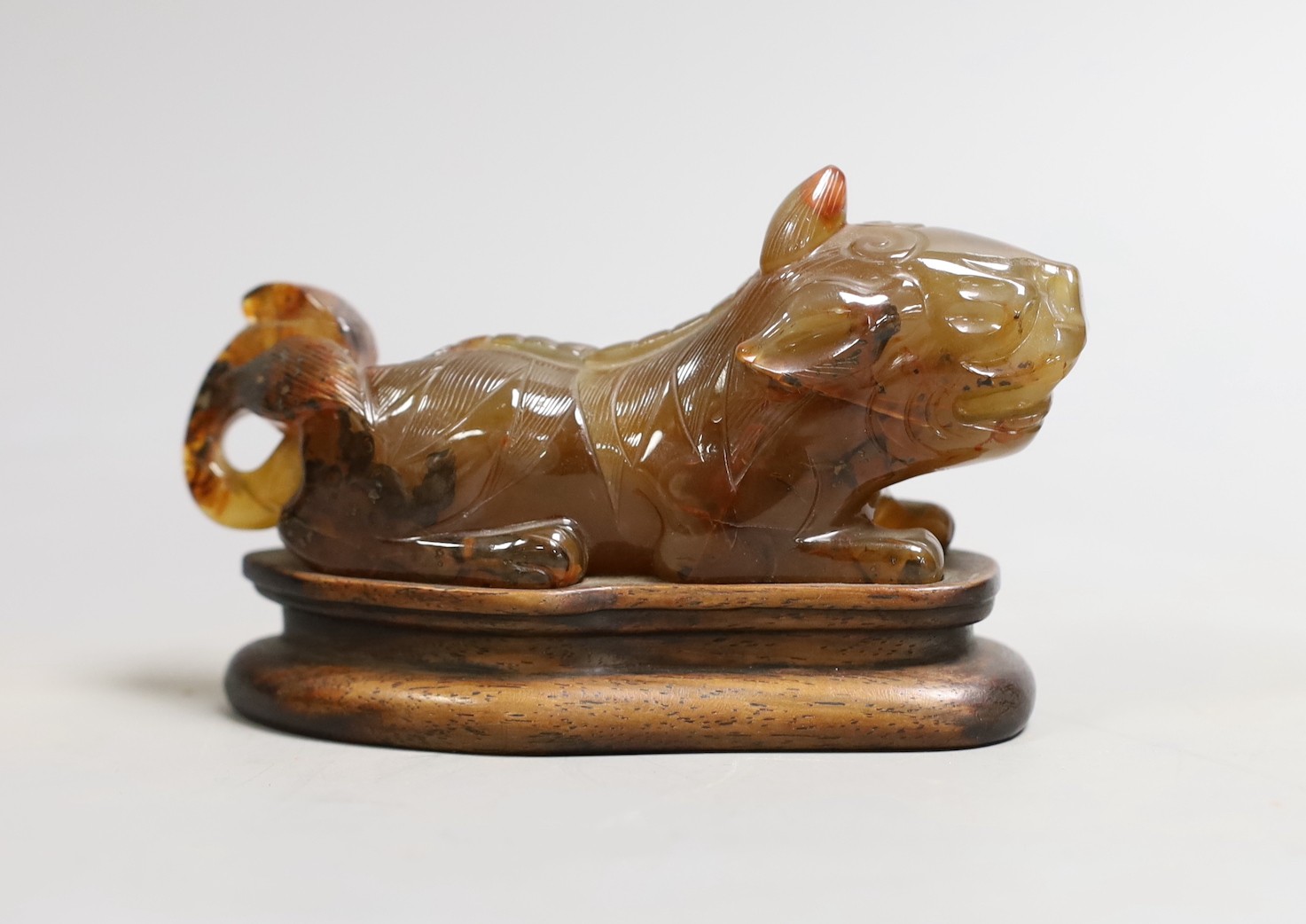 A Chinese agate recumbent lion dog figure, 13cm long